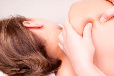 Close-up de uma massagem de ponto-gatilho no ombro para alívio de dor e tensão muscular profunda.