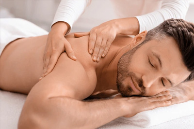 Homem atlético recebendo uma massagem profunda nas costas para recuperação muscular em uma clínica de massoterapia.