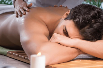 Homem relaxando profundamente enquanto recebe uma massagem nos ombros em um spa FiosioMassagem