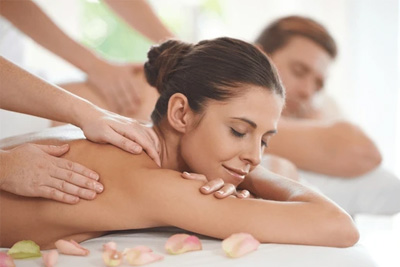 Casal recebe uma massagem relaxante lado a lado em um spa.